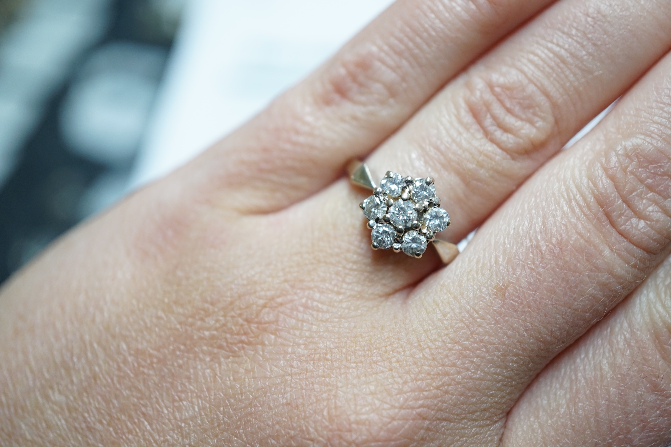 A modern 18ct white gold and seven stone diamond set hexagonal cluster ring, size O, gross weight 3.9 grams.
